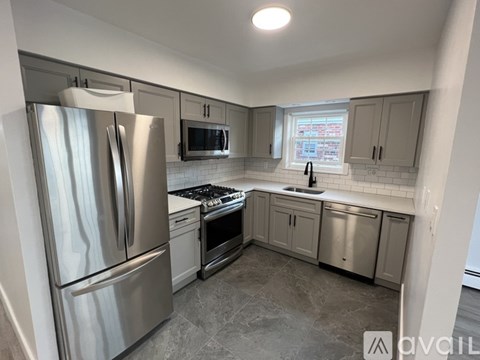 A kitchen with a stainless steel refrigerator and a stove top oven.