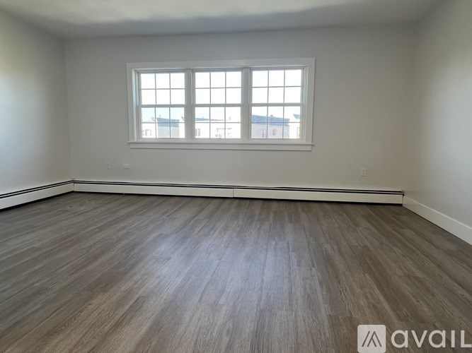 A room with wooden flooring and a window.