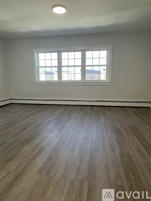 A room with wooden flooring and a window.