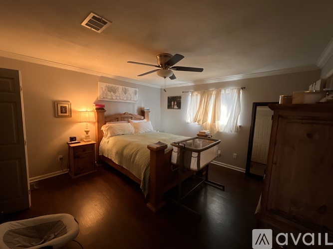 A bedroom with a bed, nightstand, and a ceiling fan.