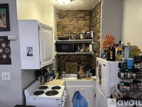 A kitchen with a white stove and a white refrigerator with many items on it.