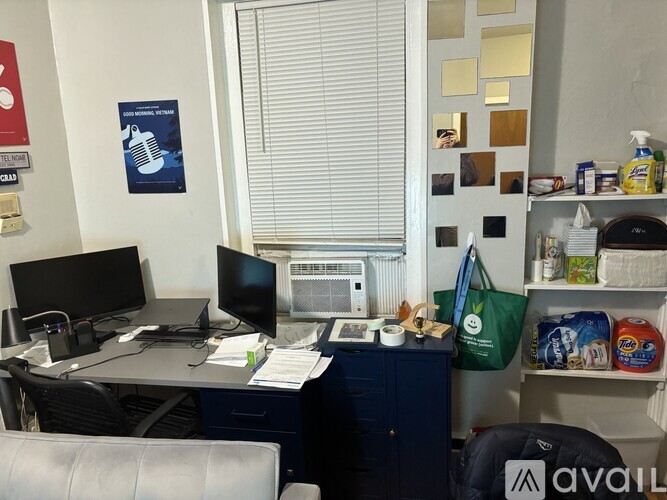 A small office with a desk, chairs, and a computer.