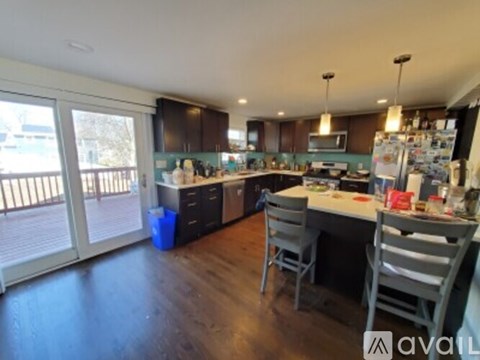 A kitchen with a table and chairs in front of it.