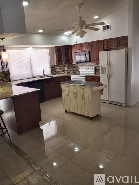 A kitchen with a white refrigerator and wooden cabinets.