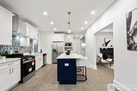 A modern kitchen with a blue island in the middle.