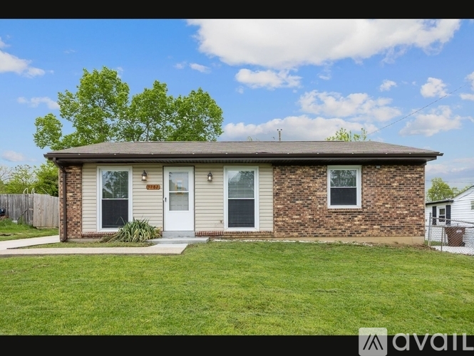 A house with a brown brick exterior and a white door is for sale.