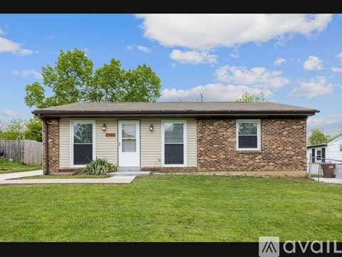 A house with a brown brick exterior and a white door is for sale.