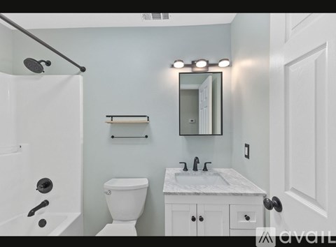 A bathroom with a white toilet, sink, and bathtub.