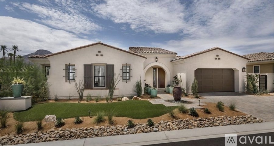 A modern house with a well-maintained garden and a driveway.