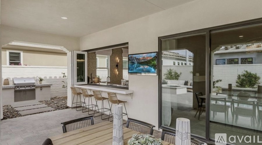 A modern outdoor patio area with a barbecue grill and seating area.