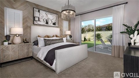 A modern bedroom with a large bed, a chandelier, and a view of the backyard through the sliding glass doors.