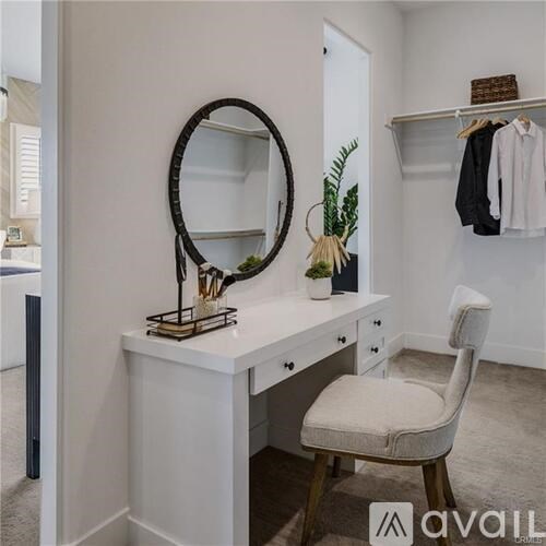 A white vanity table with a mirror and a chair.