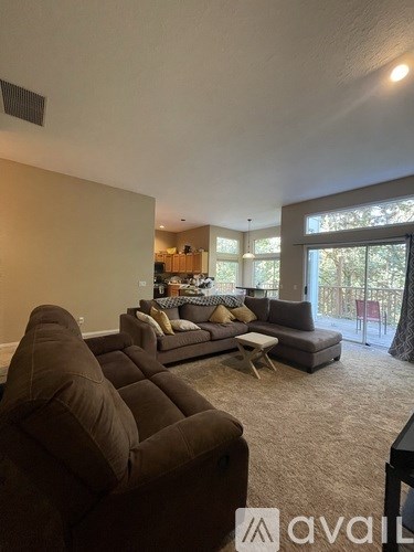 A living room with a brown couch and a carpet.