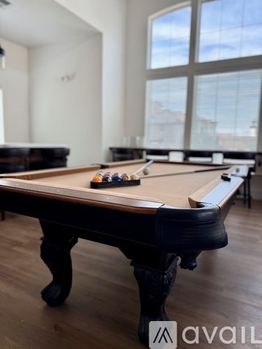 A pool table in a room with a large window.