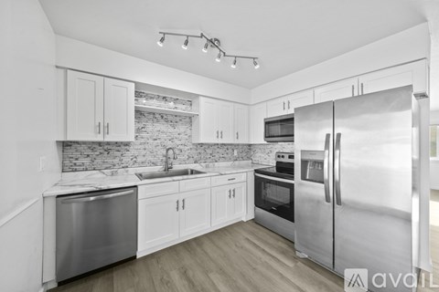 A kitchen with white cabinets and stainless steel appliances.