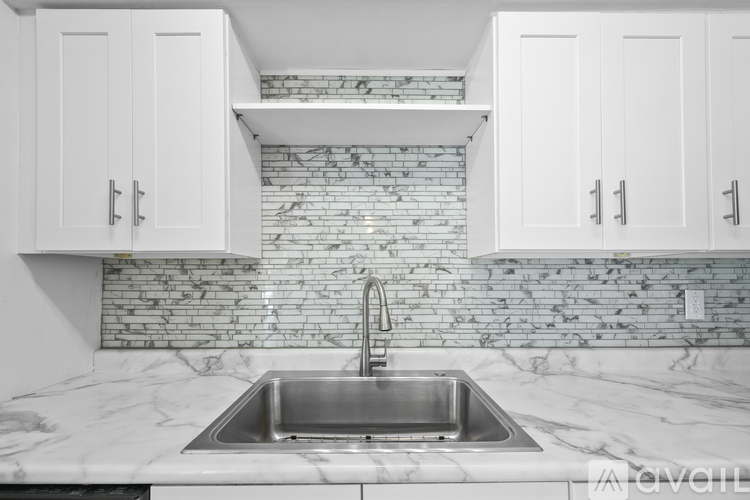 A kitchen with a marble countertop and a sink.