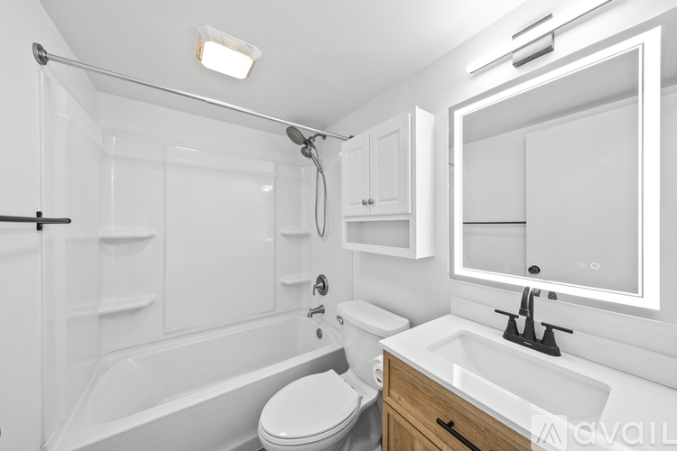 A white bathroom with a toilet, sink, and bathtub.