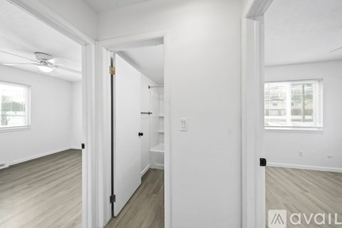 A hallway with a door on the left and a window on the right.