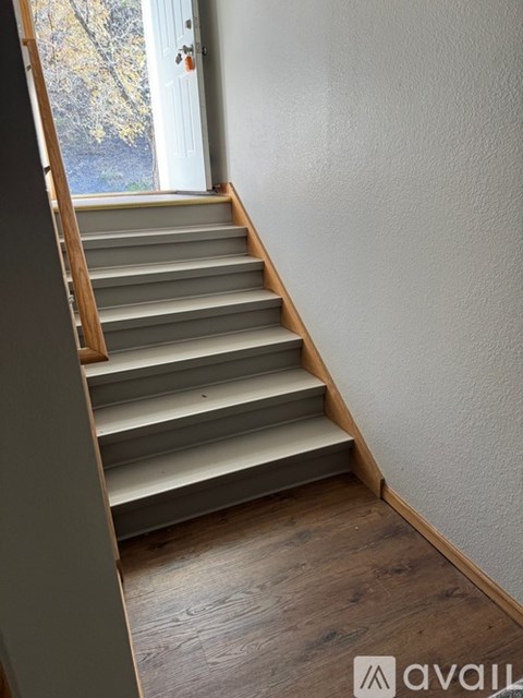 A staircase with wooden steps and a white door in the background.