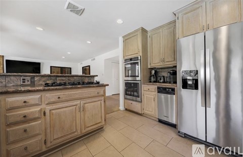 A kitchen with wooden cabinets and stainless steel appliances.