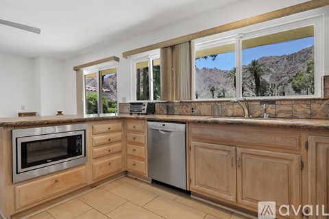 A kitchen with wooden cabinets and a stainless steel oven.