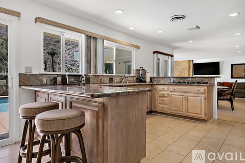 A kitchen with wooden cabinets and a bar area.