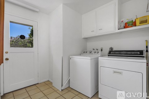 A small laundry room with a washer and dryer.