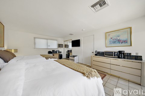 A bedroom with a large bed and a painting on the wall.