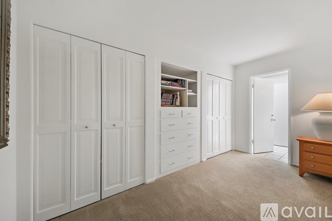 A room with white doors, drawers, and a lamp.