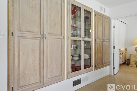 A kitchen with wooden cabinets and glass doors.