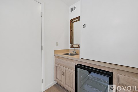 A kitchen with a white cabinet and a black fridge.