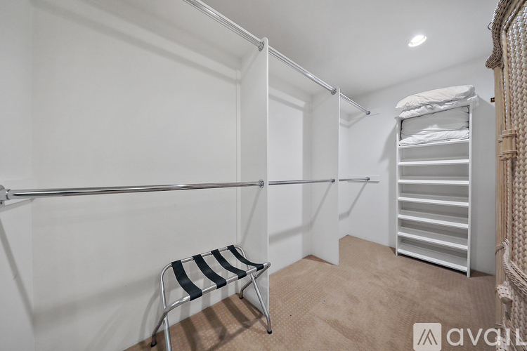 A room with a white wall and a chair with a striped seat and back.
