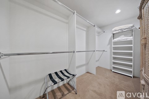 A room with a white wall and a chair with a striped seat and back.