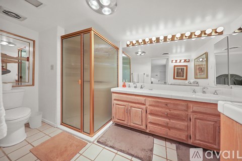 A bathroom with a glass shower door and a white toilet.