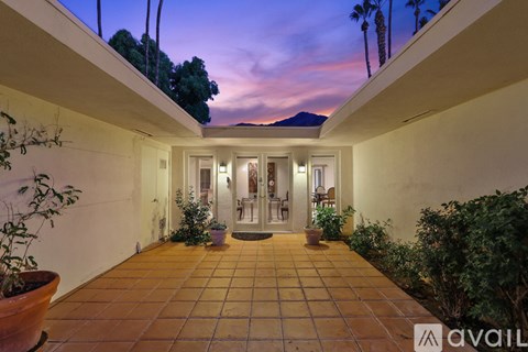 A patio with a tiled floor and potted plants.