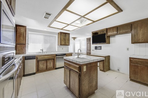 A kitchen with wooden cabinets and a central island.