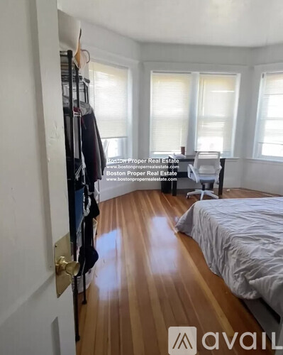 A bedroom with a bed, a chair, and a window.