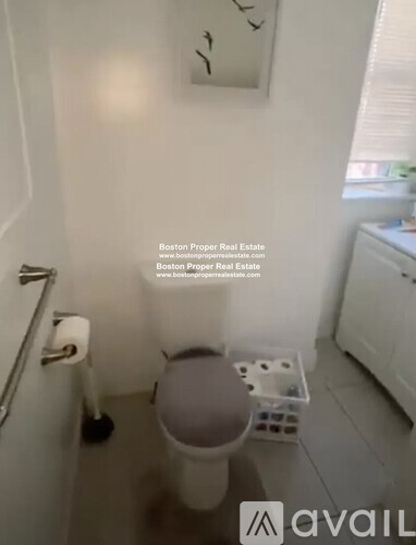 A small bathroom with a toilet and a white cabinet.