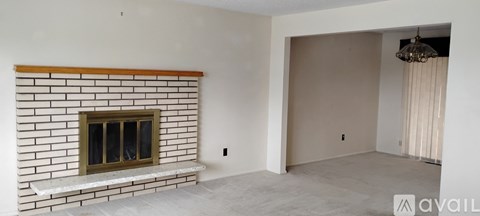 A living room with a fireplace and a chandelier.