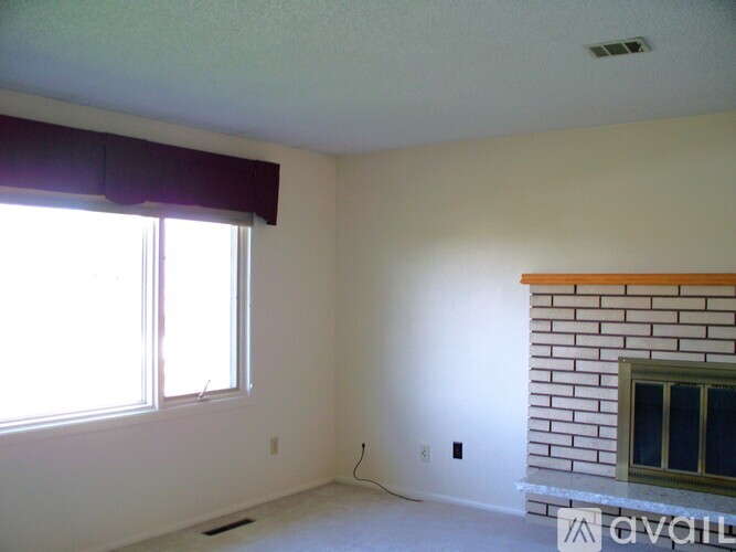 A room with a window and a fireplace.