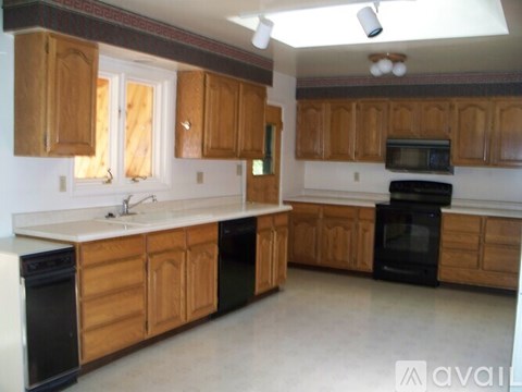 A kitchen with wooden cabinets and black appliances.
