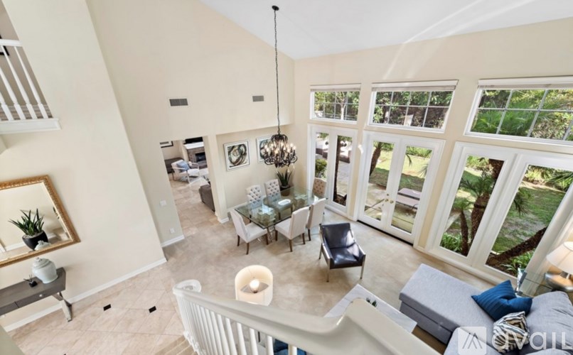 A living room with a white couch and a chandelier.