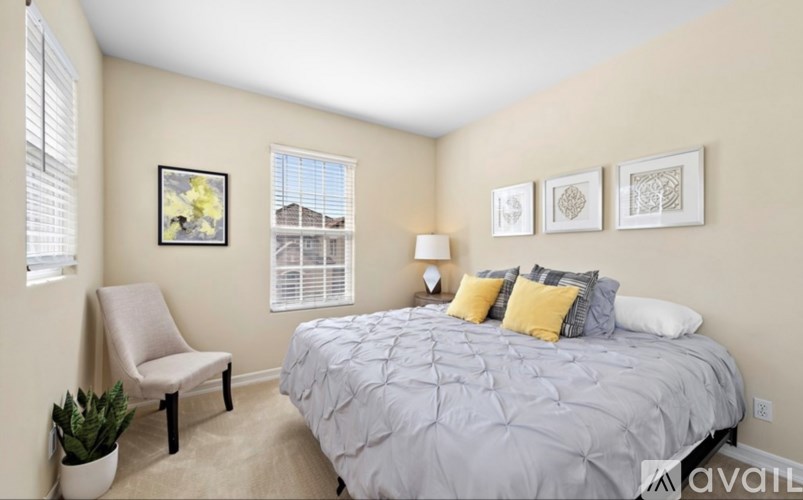 A bedroom with a bed, chair, and pictures on the wall.