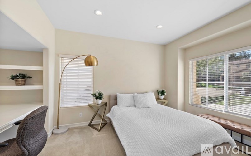 A bedroom with a bed, desk, and chair.