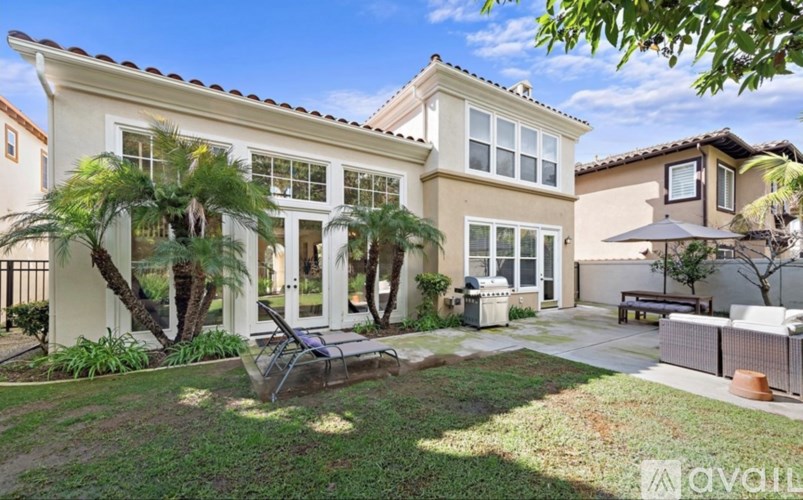 A large house with a patio and a tree in front.