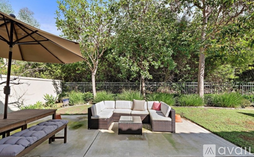 A patio with a table and chairs under an umbrella.