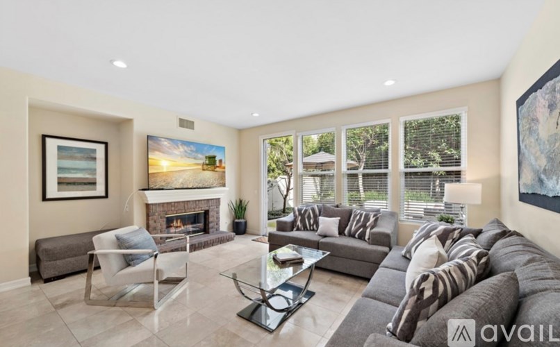 A living room with a fireplace and a painting on the wall.