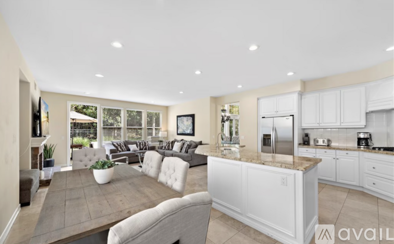 A modern kitchen with white cabinets and a large island.