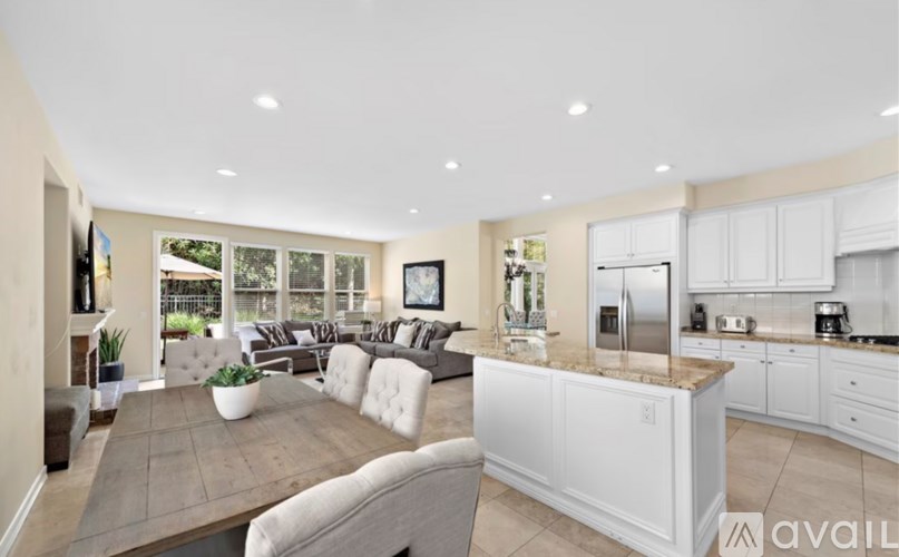 A modern kitchen with white cabinets and a large island.
