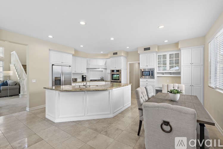 A modern kitchen with a central island and a dining area.